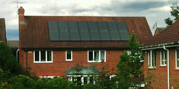 Man on roof installing PV Solar Panels