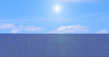 Man on roof installing PV Solar Panels